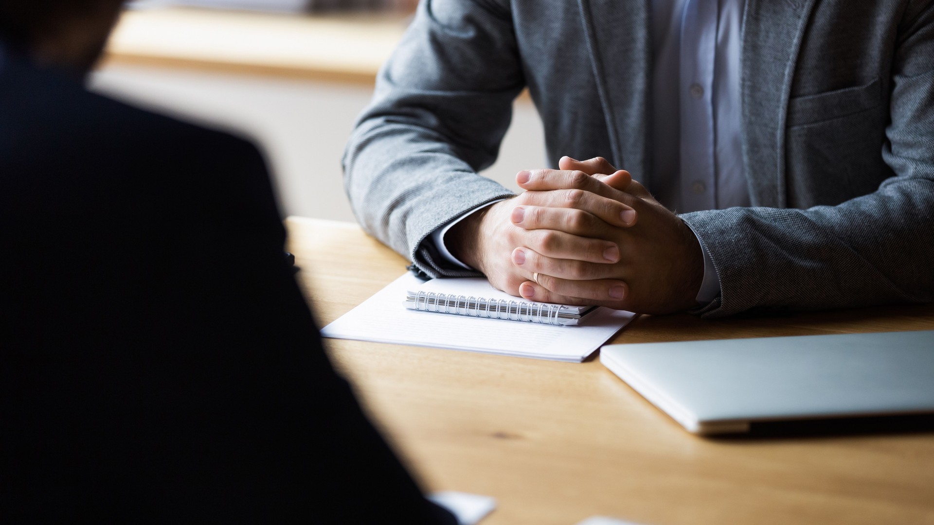 Close up focus on clasped hands of male entrepreneur.